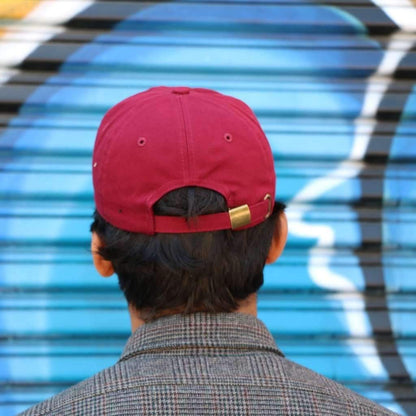 Back side of baseball hat with brass adjustable buckle