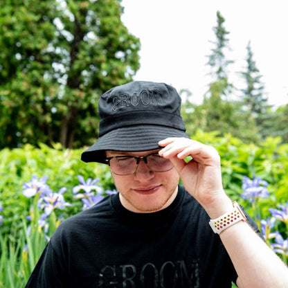 Male wearing a black bucket hat embroidered with Groom in black thread - DSY Lifestyle