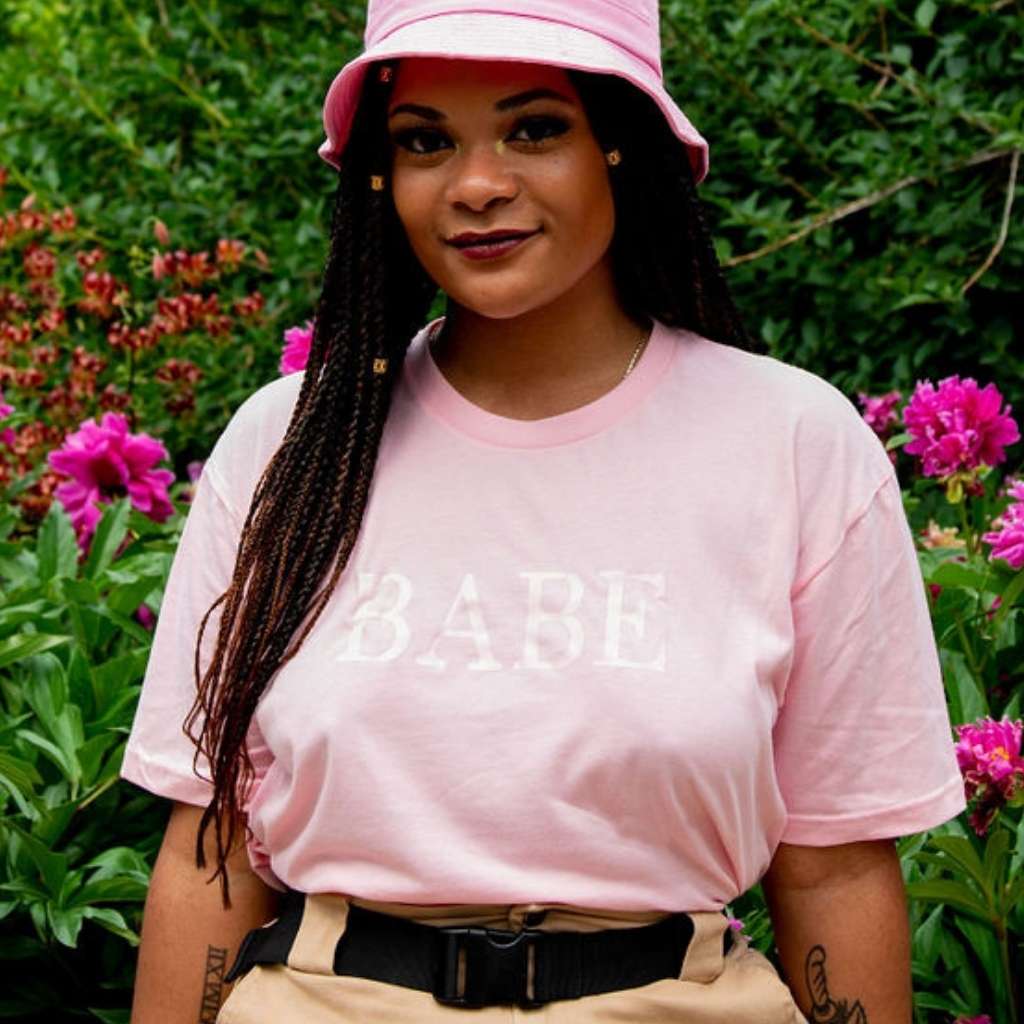 Female wearing a pink unisex tshirt printed with BABE in pink - DSY Lifestyle