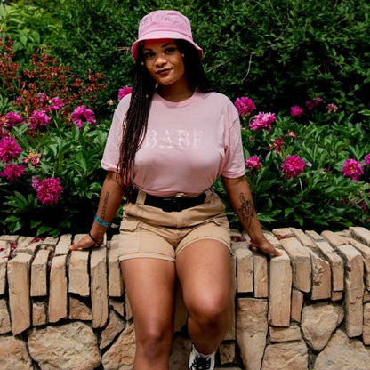 Female wearing a pink unisex tshirt printed with BABE in pink - DSY Lifestyle
