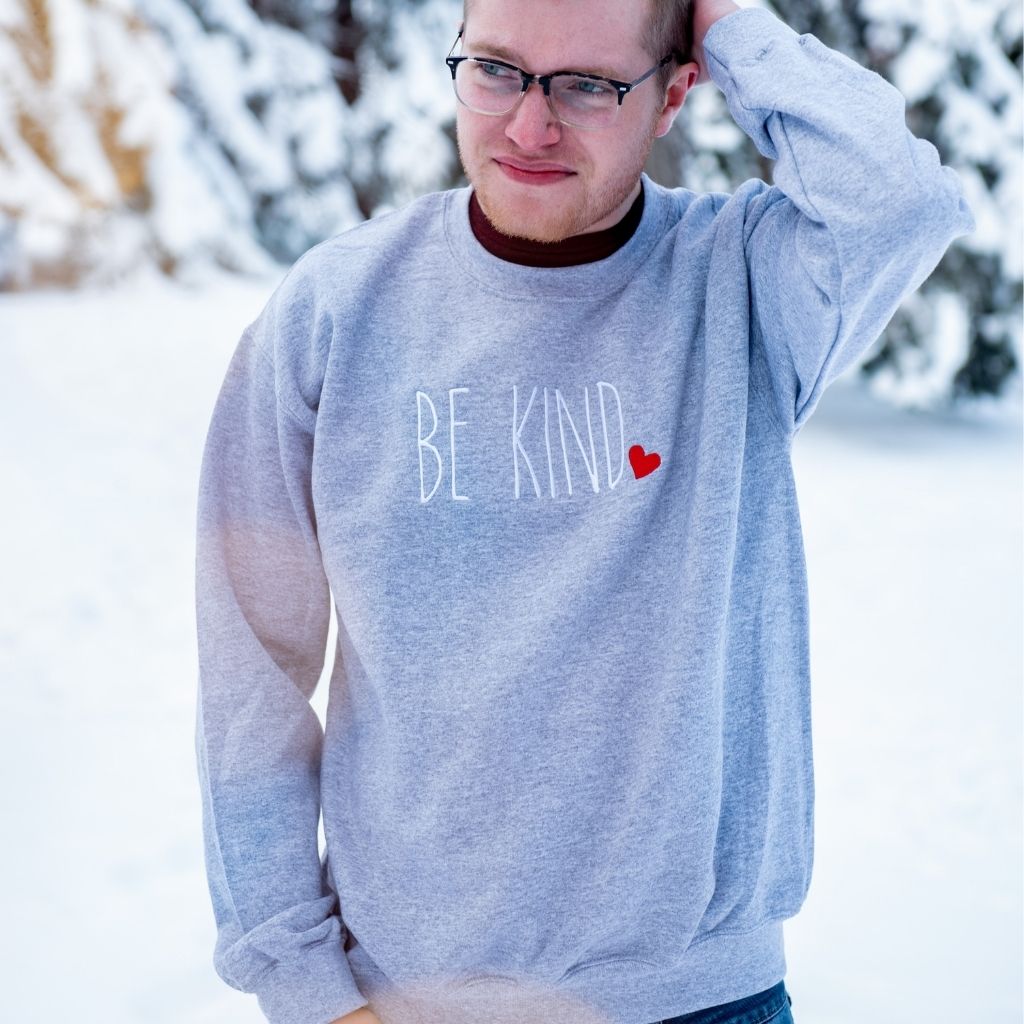 Male wearing heather gray Sweatshirt embroidered with Be Kind in the front - DSY Lifestyle