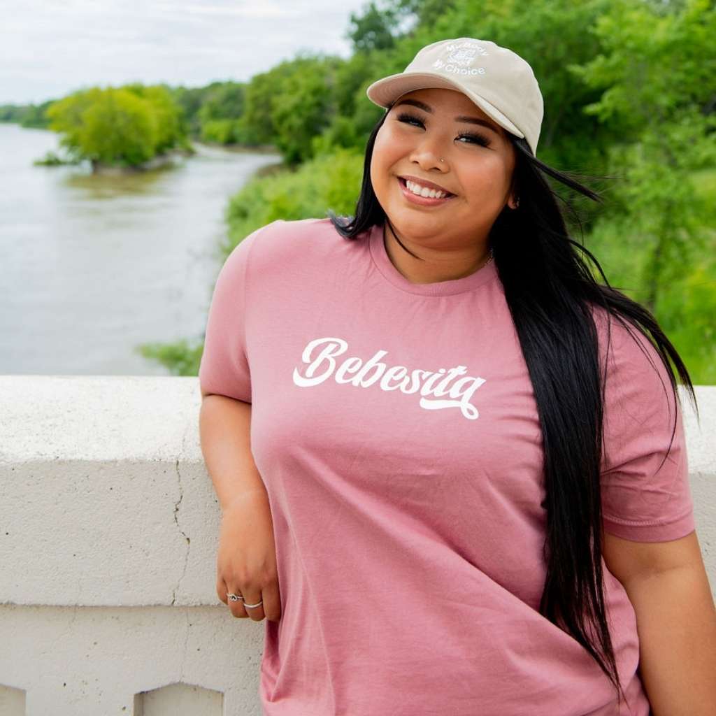 Female wearing stone color baseball hat and a Mauve T-shirt with Bebesita printed in the front- DSY Lifestyle