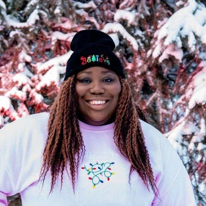 Model wearing black cuffed beanie with Believe embroidered with Christmas symbols - DSY Lifestyle