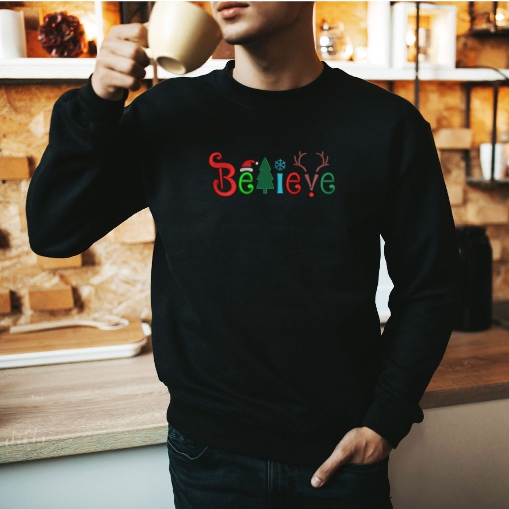 Male wearing a black sweatshirt embroidered with Believe in the front -DSY Lifestyle
