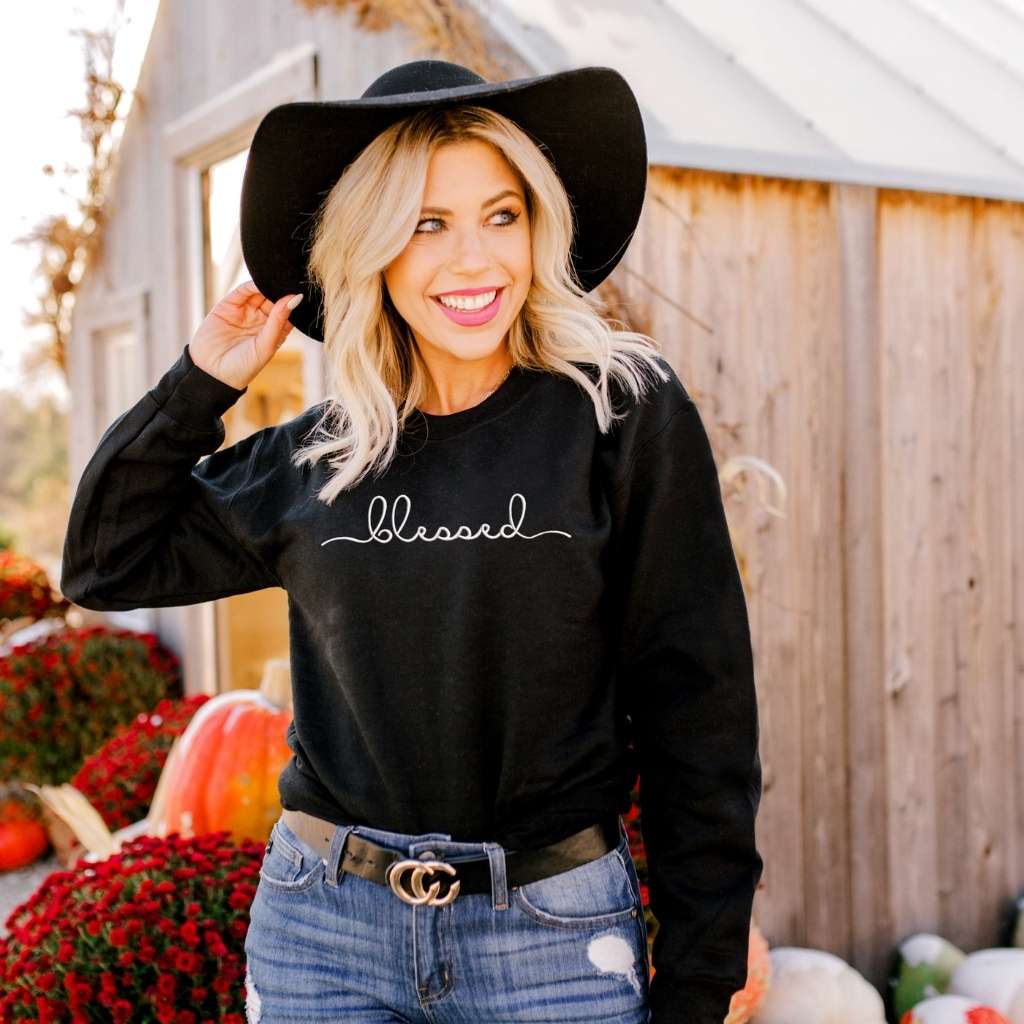 Female wearing a black sweatshirt embroidered with blessed in the front - DSY Lifestyle