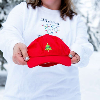 Woman holding a red baseball hat embroidered with a Christmas Tree - DSY Lifestyle