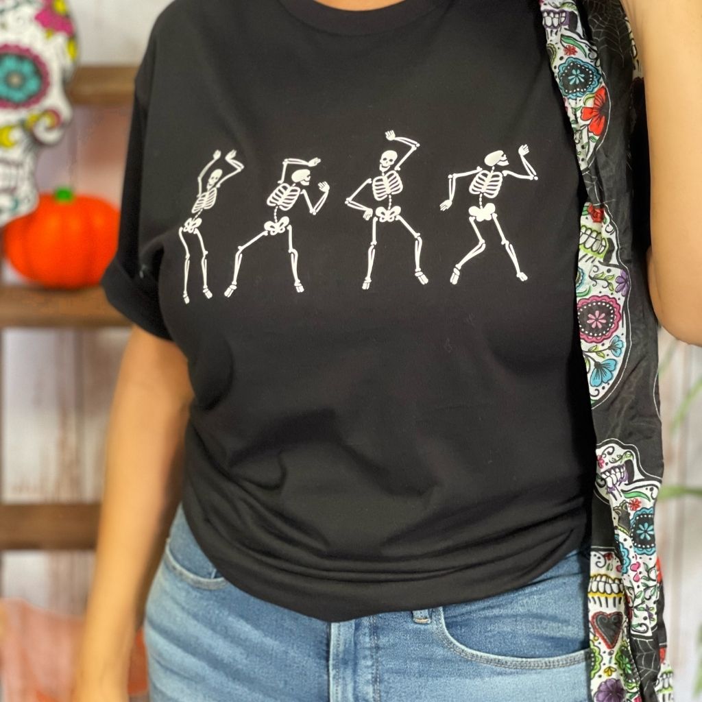 close up of Female wearing a black unisex t-shirt with printed white dancing skeletons in the front - DSY Lifestyle