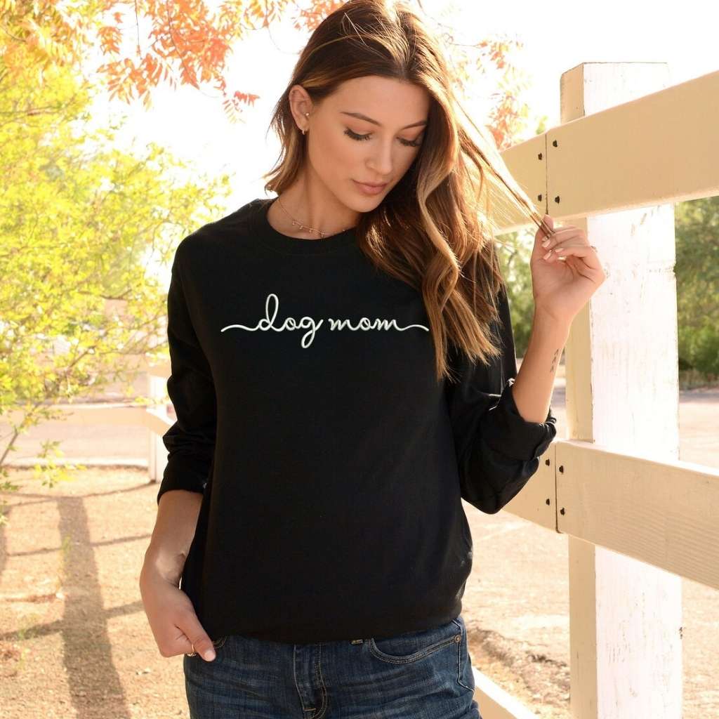 Female wearing a black crewneck sweatshirt embroidered with dog mom - DSY Lifestyle