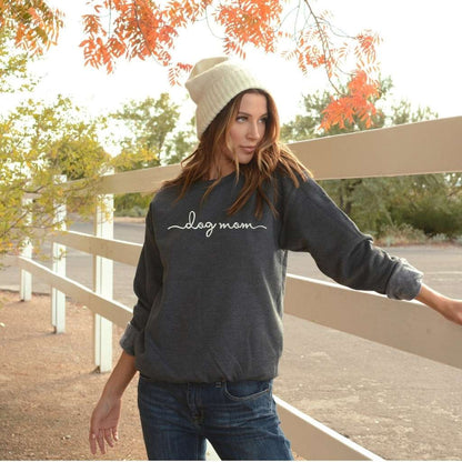 Female wearing a dark gray crewneck sweatshirt embroidered with dog mom - DSY Lifestyle