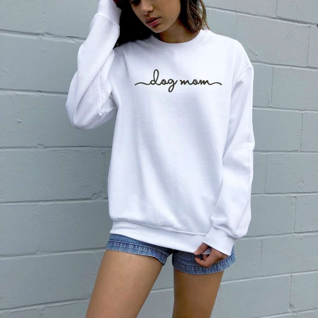 Female wearing a white crewneck sweatshirt embroidered with dog mom - DSY Lifestyle