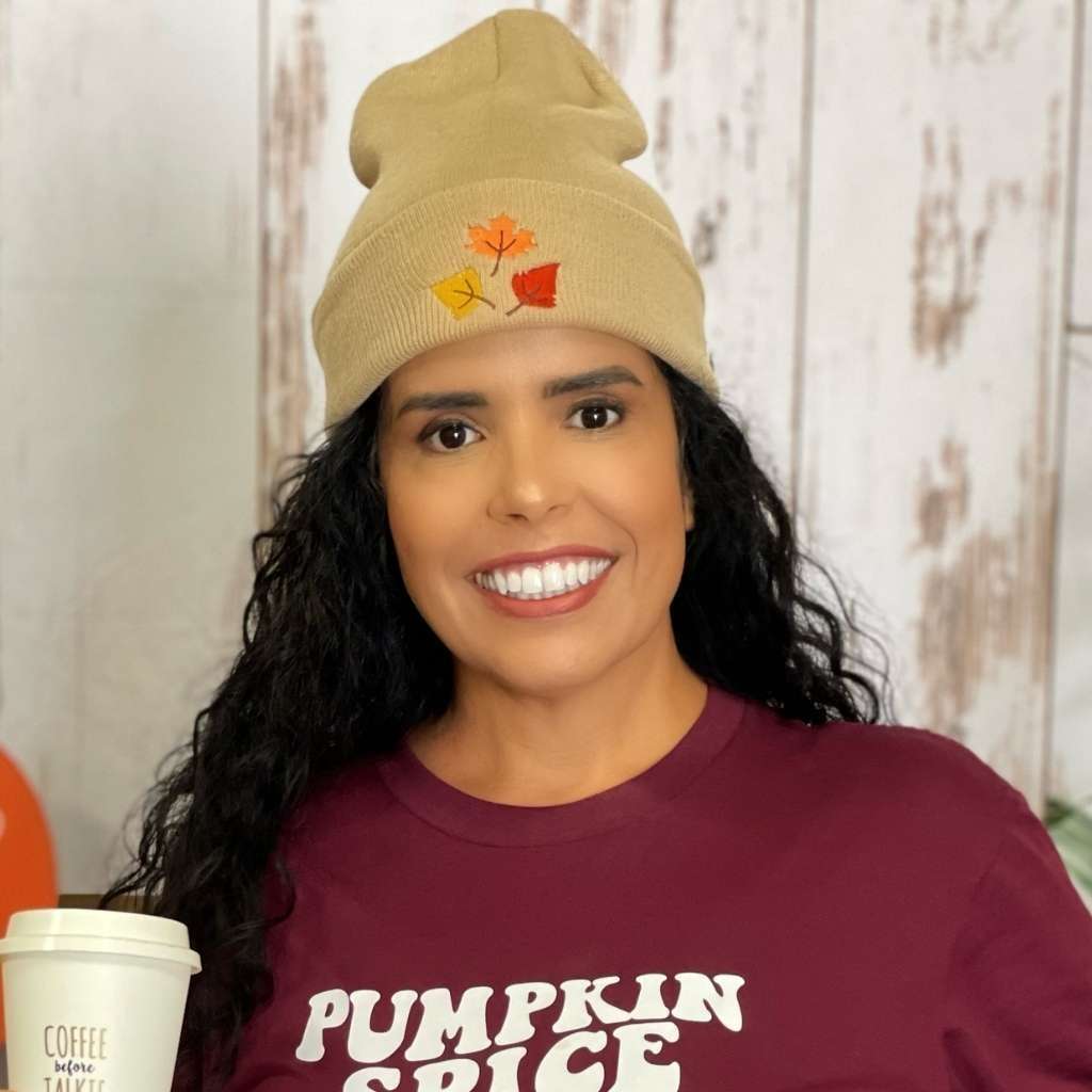 Model wearing tan cuffed beanie with orange, yellow, and red fall leaves embroidered on the front - DSY Lifestyle