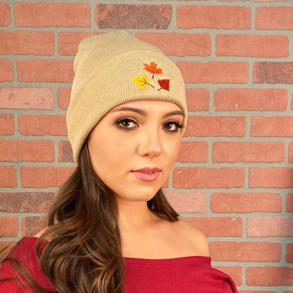 Model wearing tan cuffed beanie with orange, yellow, and red fall leaves embroidered on the front - DSY Lifestyle