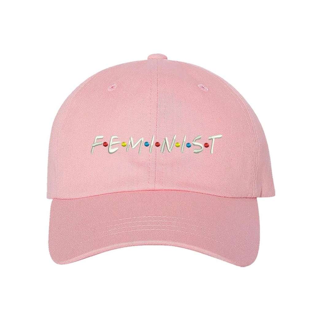 Light pink baseball hat with FEMINIST embroidered in white with multicolored dots in between letters - DSY Lifestyle