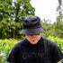 Male wearing a black bucket hat embroidered with Groom in black thread - DSY Lifestyle