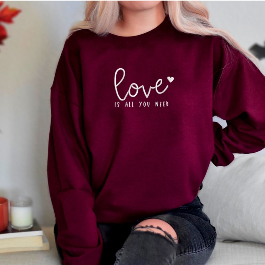 Female wearing Maroon sweatshirt embroidered with Love is all you need - DSY Lifestyle