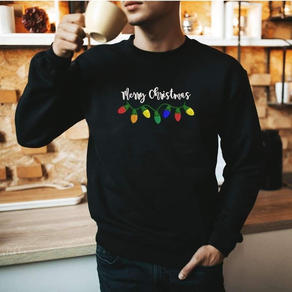 Male wearing a black sweatshirt embroidered with Merry Christmas in the front - DSY Lifestyle