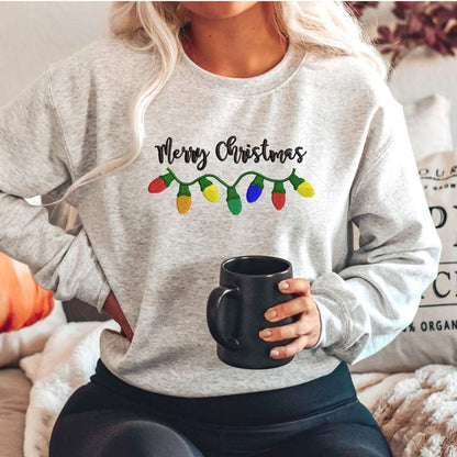 Female wearing a heather gray crewneck sweatshirt embroidered with Merry Christmas in the front- DSY Lifestyle