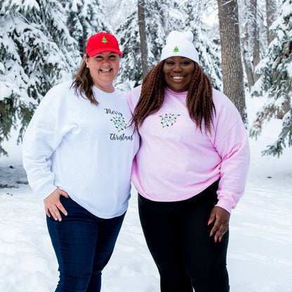 Two females in the snow wearing sweatshirts embroidered with Merry Christmas - DSY Lifestyle