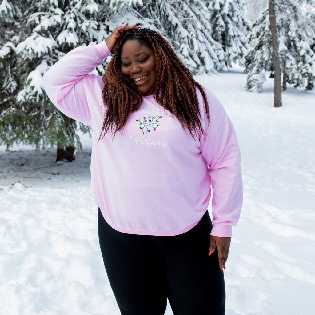 Female wearing a pink sweatshirt embroidered with Merry Christmas in the front - DSY Lifestyle