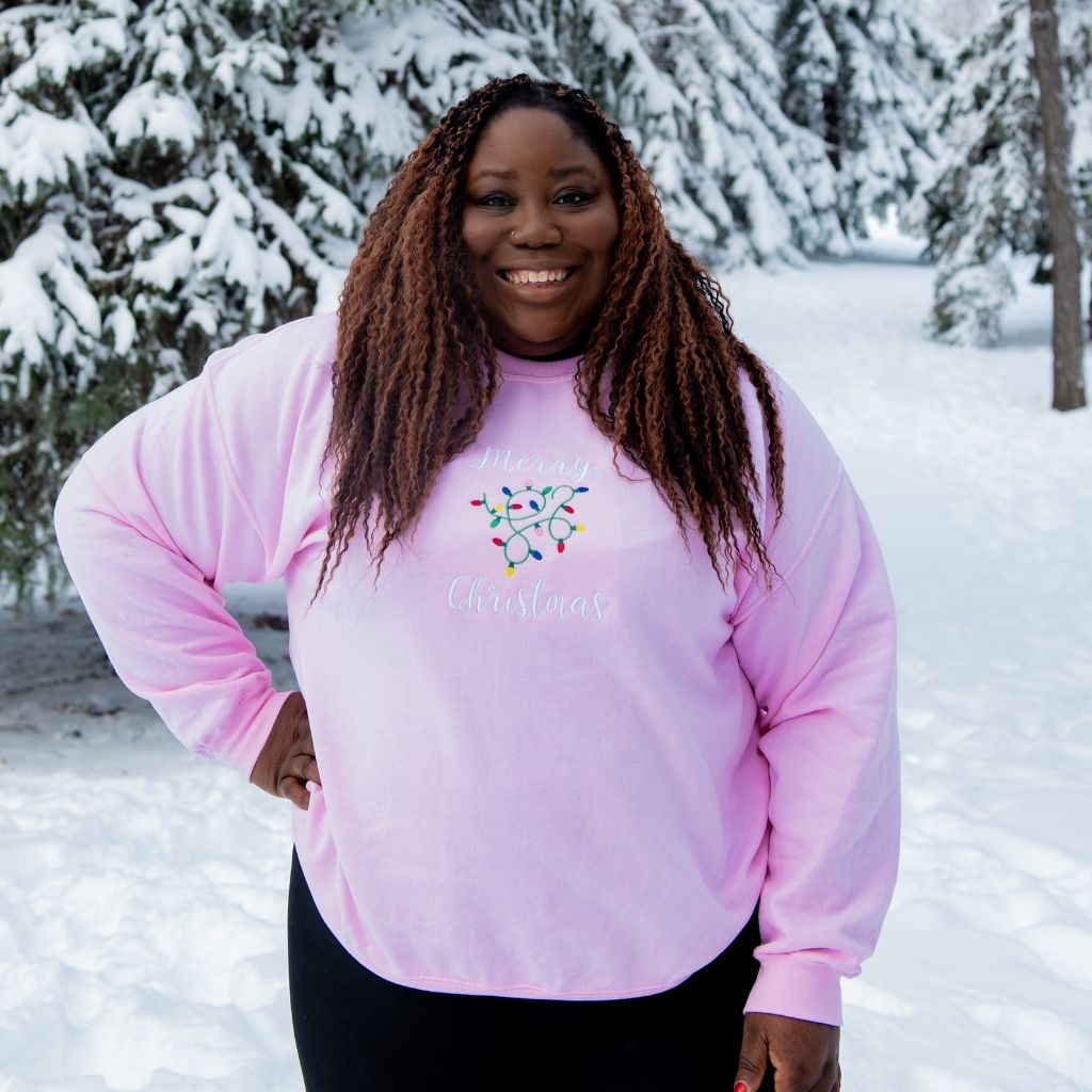 Female wearing a pink sweatshirt embroidered with Merry Christmas in the front - DSY Lifestyle