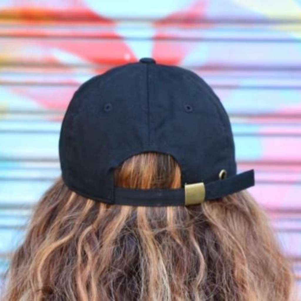 Female model wearing a black baseball hat with brass buckle - DSY Lifestyle