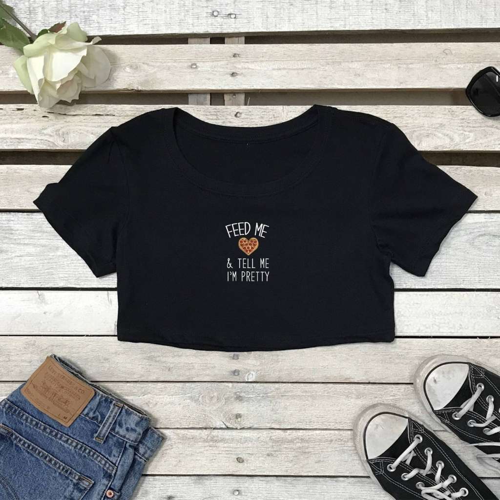 Flat lay of black crop top with Feed me pizza and call me pretty printed on the front in white - DSY Lifestyle
