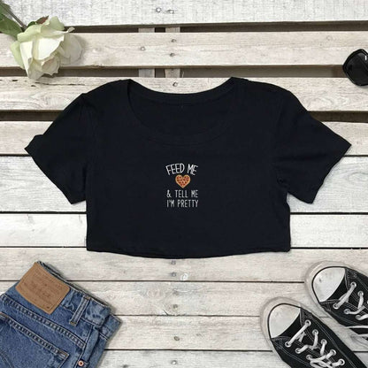 Flat lay of black crop top with Feed me pizza and call me pretty printed on the front in white - DSY Lifestyle