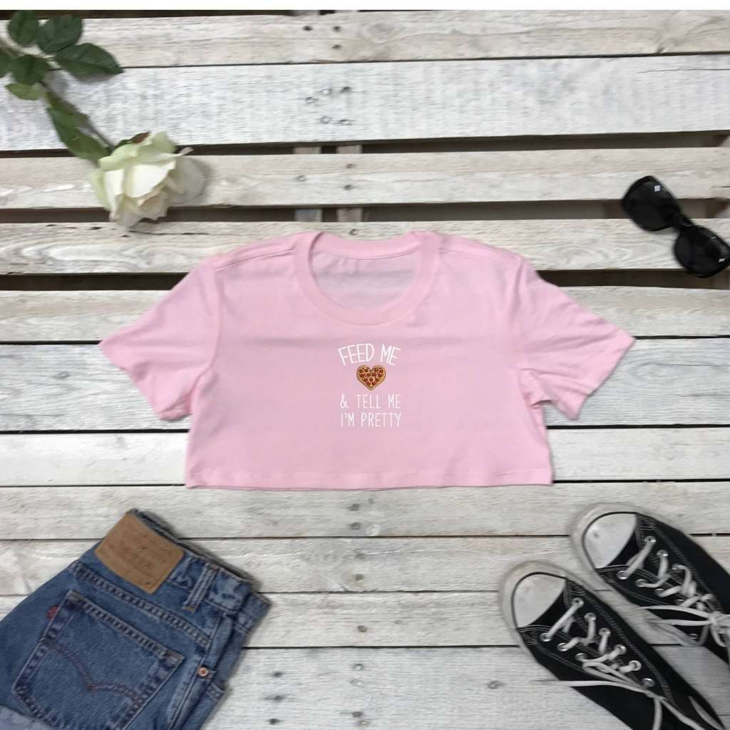 Flat lay of pink underboob top with feed me and call me pretty printed on the front in white - DSY Lifestyle