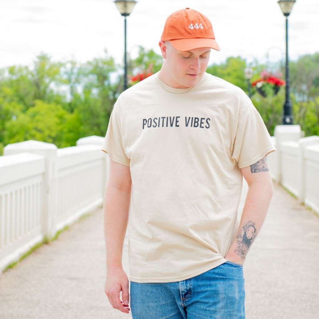 Man wearing a cream graphic tshirt with Positive Vibes printed in the front- DSY Lifestyle