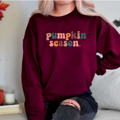 Female wearing a burgundy crewneck sweatshirt printed with pumpkin season in the front - DSY Lifestyle
