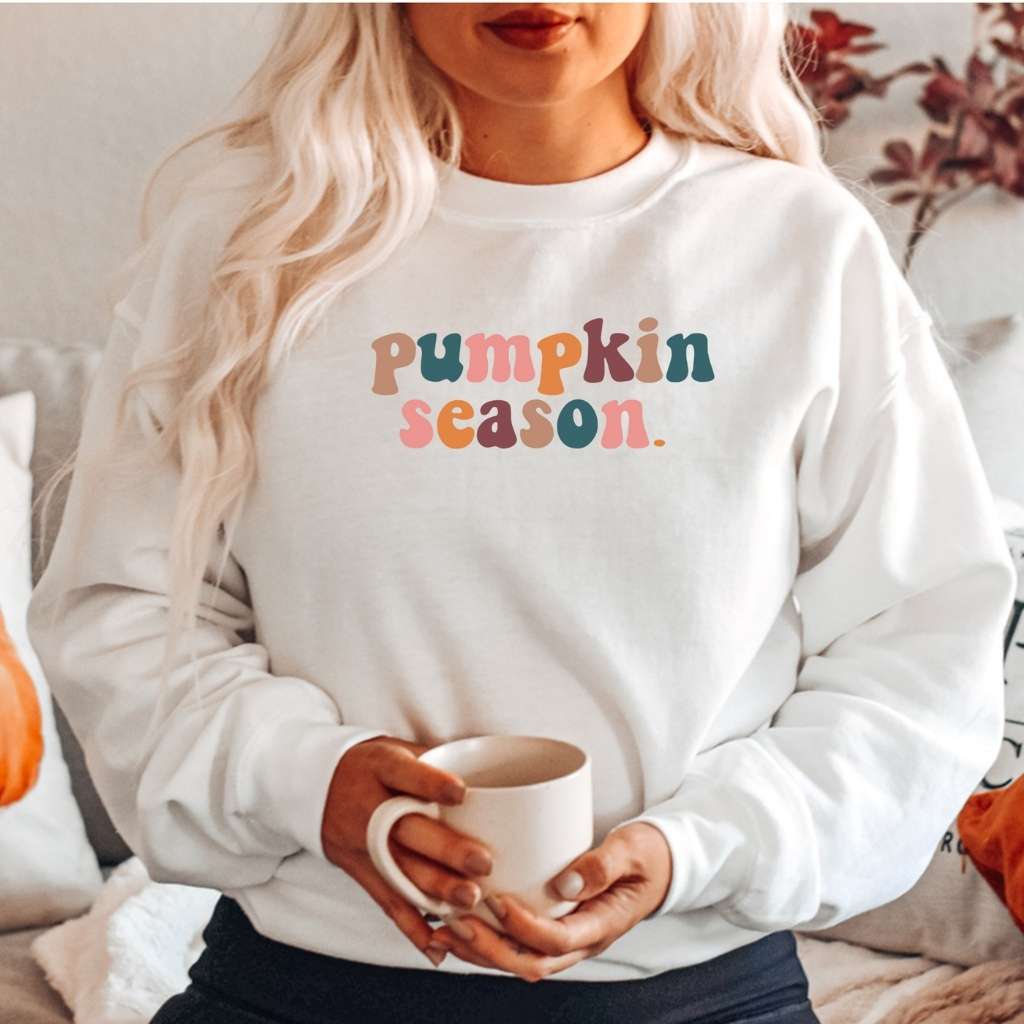 Female wearing a white crewneck sweatshirt printed with pumpkin season in the front - DSY Lifestyle