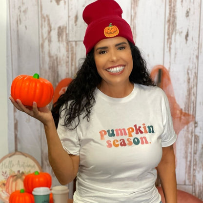 Female holding a pumpkin and wearing a white tshirt with pumpkin season printed in the front and wearing a burgundy beanie with a pumpkin embroidered in the front - DSY Lifestyle