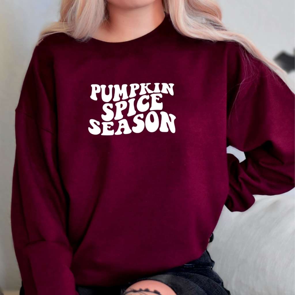 Female wearing a Unisex burgundy sweatshirt with pumpkin spice sprinted in the front in white - DSY Lifestyle
