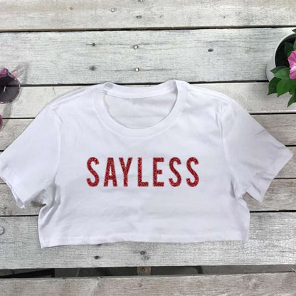 Flat lay of white underboob top with sayless on the front in red glitter vinyl - DSY Lifestyle