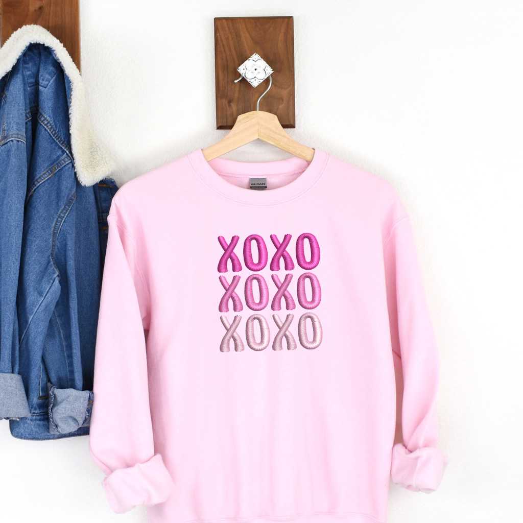 Flat lay of a Light Pink sweatshirt embroidered with XOXO in shades of Pink - DSY Lifestyle