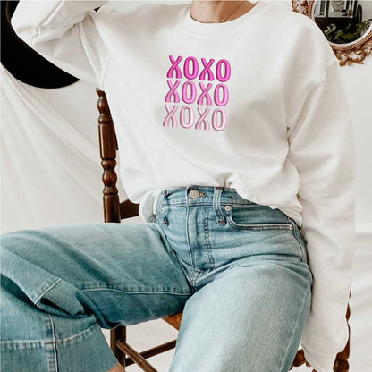 Female wearing a white sweatshirt embroidered with XOXO in shades of Pink - DSY Lifestyle
