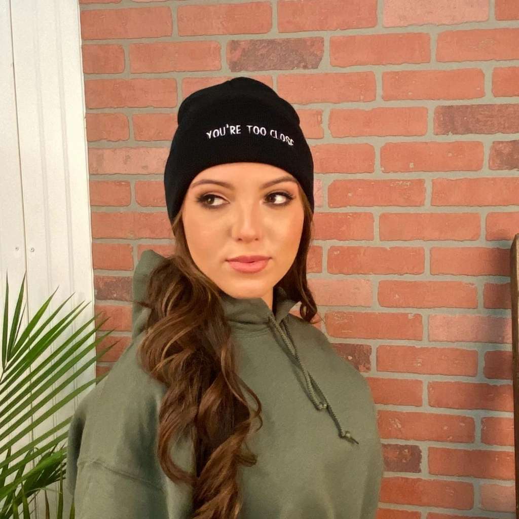 Female modeling black cuffed beanie with You&