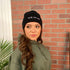 Female modeling black cuffed beanie with You&